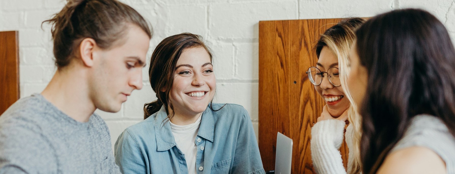 Quatre personnes souriantes autour d'une table de travail